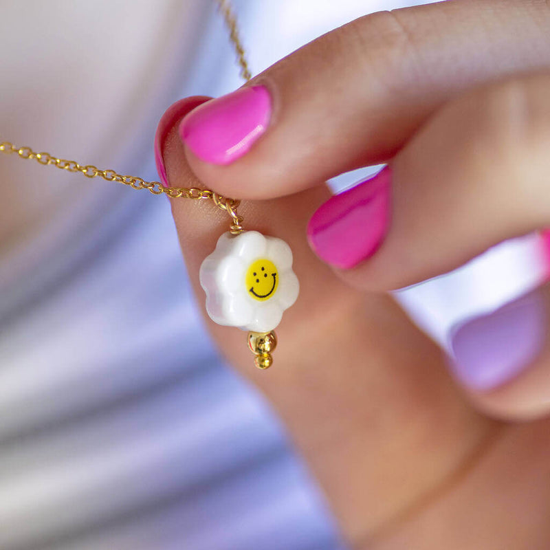 Image shows model holding Smiley Face Flower Necklace