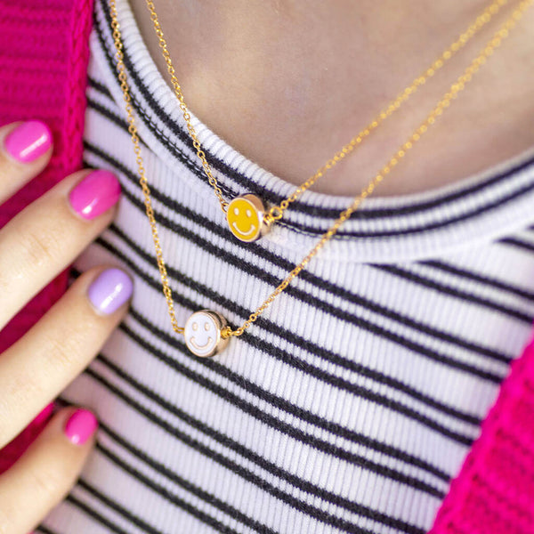 Image shows model wearing yellow and white Smiley Face Necklaces