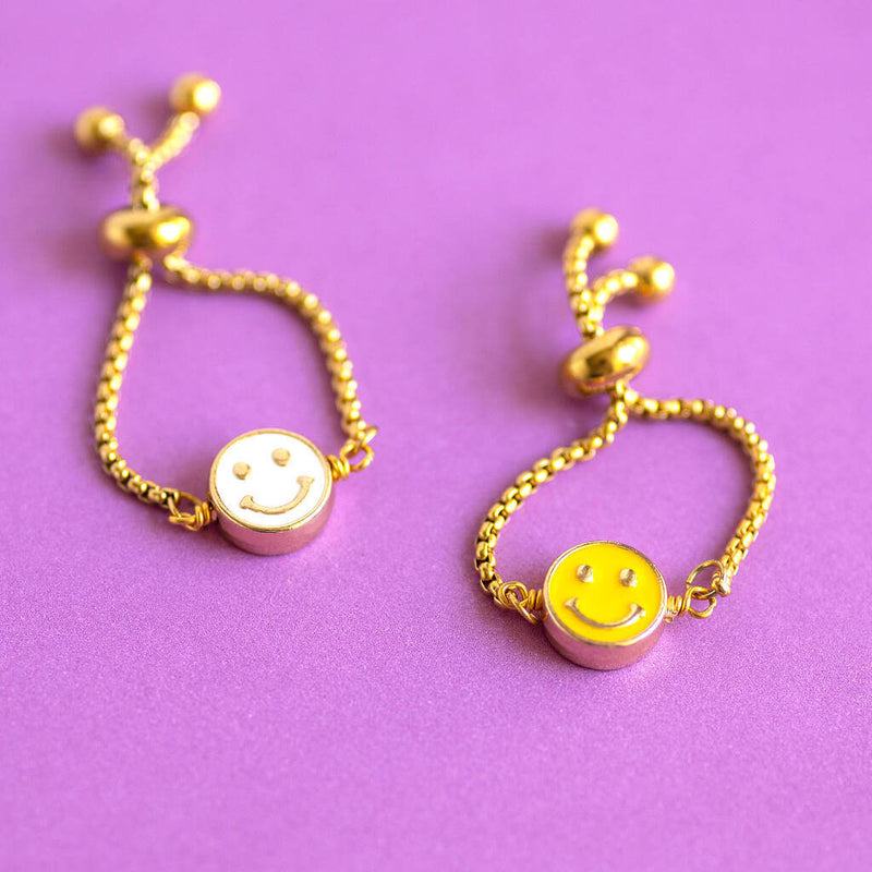 Image shows white and yellow Smiley Face Slider Chain Rings on purple background