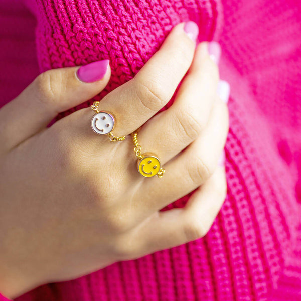 Image shows model wearing white and yellow Smiley Face Slider Chain Rings 