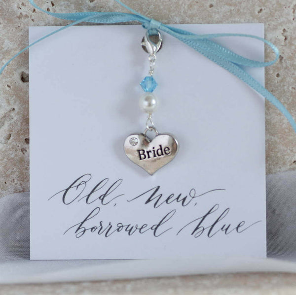 Something blue brides heart charm presented on an old new borrowed blue sentiment card by baby blue ribbon