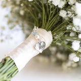Something blue brides heart charm attached to wrapped ribbon round a wedding  bouquet