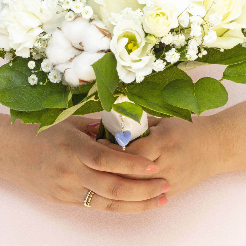 Image shows model holding a wedding bouquet with Something Blue Ceramic Heart Keepsake Charm attached to it