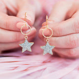 Image shows model holding Sparkle Star Circle Drop Earrings