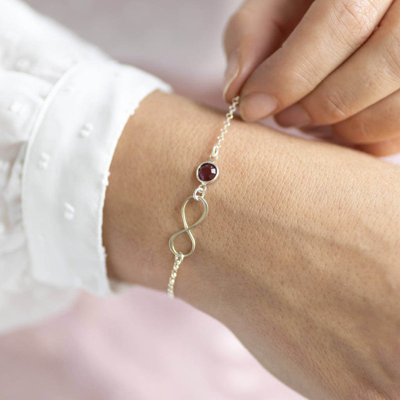 Image shows model wearing Sterling Silver Infinity Birthstone Bracelet with July birthstone