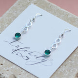 Image shows model wearing sterling silver infinity birthstone earrings with  May birthstones on an Infinity sentiment card