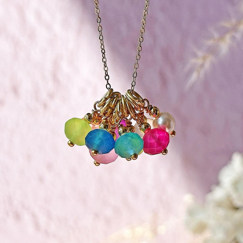 Image shows Summer Essential Multiwear Bright Charm Necklace hanging against a blurred background
