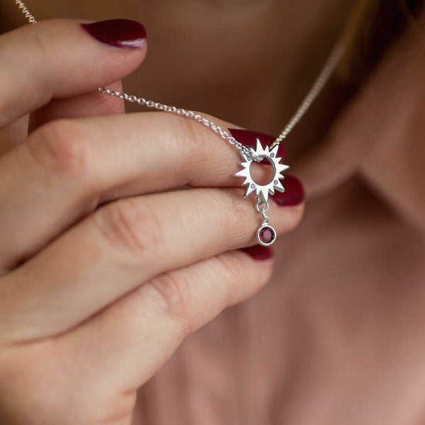 Image shows model holding silver Sunburst Necklace With White Opal And Birthstone Detail