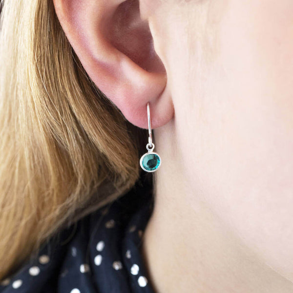 Image shows model wearing Swarovski crystal birthstone earrings  with December birthstone