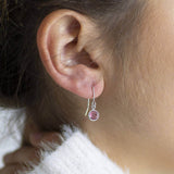 Image shows model wearing Swarovski crystal birthstone earrings with October birthstone