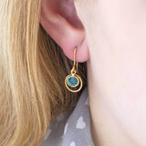 Image shows model wearing gold Swarovski eternity birthstone earrings with March birthstone