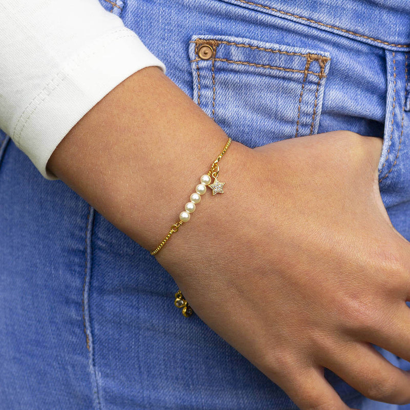 Image shows model wearing gold Swarovski Pearl Slider Charm Bracelet