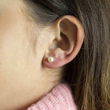 Image shows model wearing Swarovski Pearl Stud Earrings