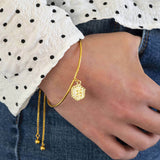 mage shows model wearing gold textured hexagon initial bangle bracelet with the initial E