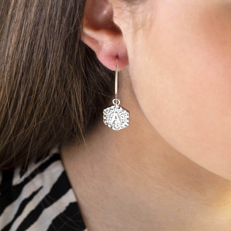 Image shows model wearing silver Textured Hexagon Initial Hoop Earrings