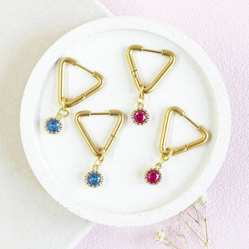 Image shows 2 sets of Triangle Huggie Earrings with Birthstone Detail July and March birthstones