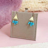 Image shows Triangle Studs with Turquoise Bead Drop Detail