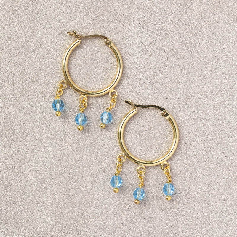 Image shows gold Triple Birthstone Huggie Hoop Earrings with March birthstone