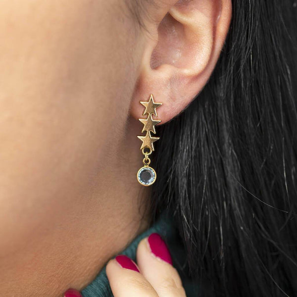Image shows model wearing triple star birthstone earrings 