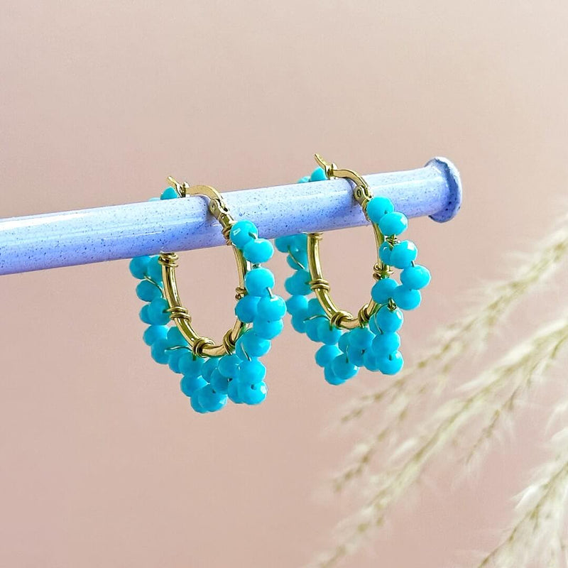 Image shows Turquoise Beaded Crystal Hoops hanging from a pole
