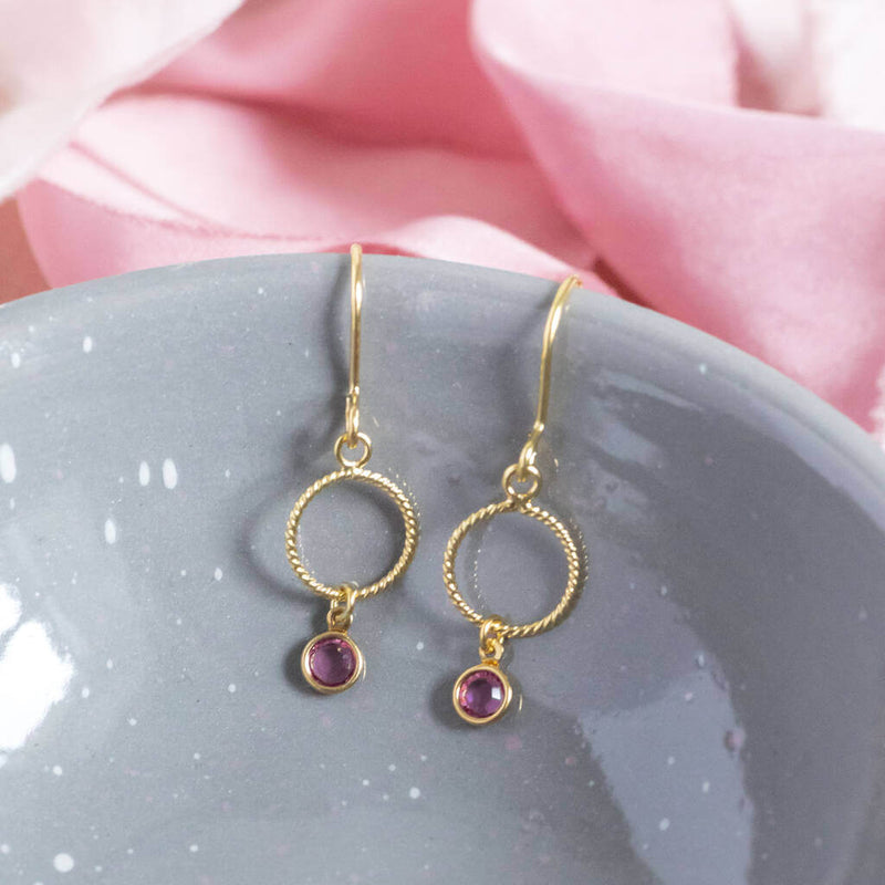 Image shows  twisted gold circle mini birthstone earrings with October birthstone