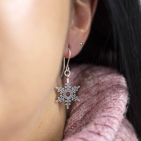 Image shows model wearing vintage style snowflake earring