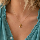 Personalised gold bubble initial necklace with B letter pendant worn on a fine gold chain