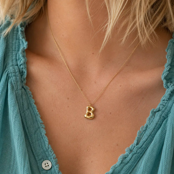 Personalised gold bubble initial necklace with B letter pendant worn on a fine gold chain
