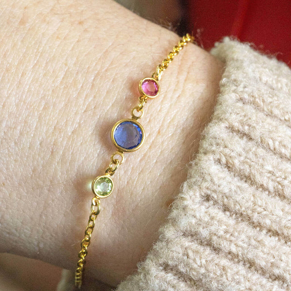 Mother and two children gold round birthstone bracelet. One big birthstone in the middle of the bracelet to represent mum and 2 smaller birthstones either side to represent two children.