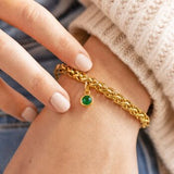 Gold plated rope chain bracelet with an emerald green birthstone charm, bold everyday jewellery with colour.