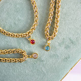 Gold plated chunky rope chain bracelets with colourful birthstone charms, modern stacking jewellery collection.