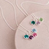 Silver birthstone charm pendants with colourful crystal details, timeless personalised jewellery for layering.