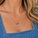 Gold birthstone rings necklace styled with denim, featuring vibrant crystal rings for everyday wear