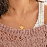 Gold plated initial birthstone disc necklace styled with a soft knit, colourful personalised jewellery for everyday layering.