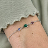 Silver plated birthstone bracelet with emerald, blue and purple crystal charms, colourful jewellery for effortless layering.