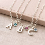 Silver initial charm jewellery with colourful birthstone crystals, personalised bracelets and necklaces for layering.