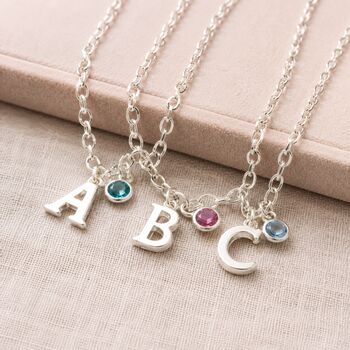 Silver initial charm jewellery with colourful birthstone crystals, personalised bracelets and necklaces for layering.