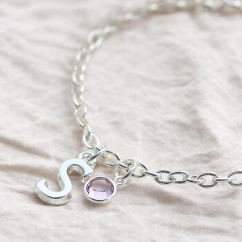 Silver initial charm bracelet with a pink birthstone crystal, timeless personalised jewellery for stacking and styling.