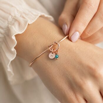Rose gold knot bangle with personalised charms, timeless jewellery designed for layering and everyday wear.