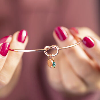  Rose gold friendship knot bangle with colourful birthstone and initial charms, delicate personalised jewellery.