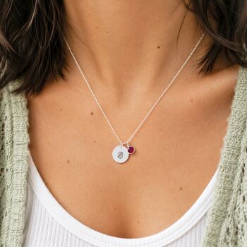 Silver plated modern initial disc necklace styled with a colourful birthstone charm for a minimalist layered look