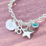 Silver birthday charm bracelet with number pendant, star charm and aqua blue birthstone accent