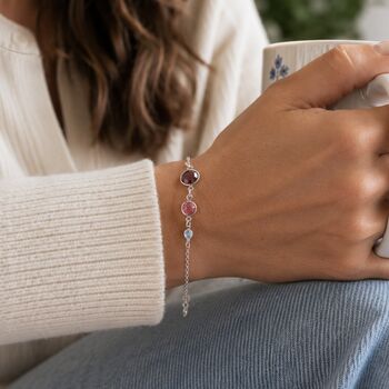 Silver birthstone bracelet with pink, lilac and burgundy crystals styled in a cosy everyday look