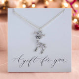 image shows a silver plated reindeer necklace presented on A gift for you sentiment card on a pink sparkly background