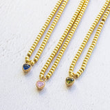 Image shows three Beaded Birthstone Heart Charm Slider Bracelets, from left: September Sapphire, October Rose and August Peridot on a white backdrop.