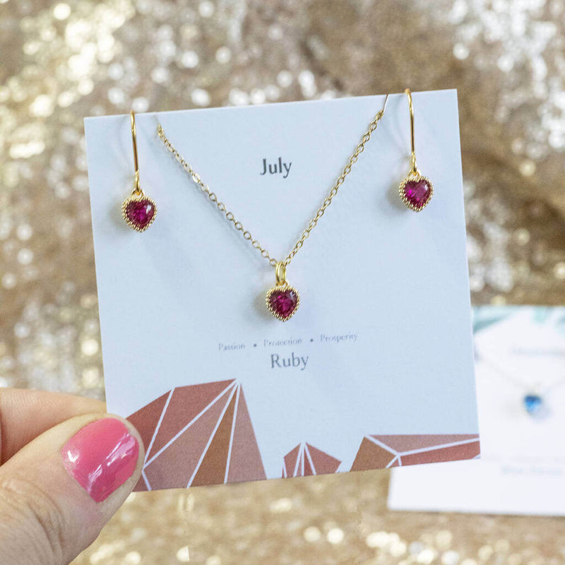 Model holds Birthstone Hearts Jewellery Set in July Ruby birthstone on a 'July" sentiment card.
