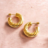 Chunky gold hoop earrings with a twisted sculptural finish, perfect for creating a polished statement look