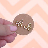 Gold bow earrings presented on craft card made by Pocketful of Joy.