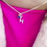 Model wears Child's Silver Plated Initial and Birthstone Necklace with the letter "H" and September birthstone.