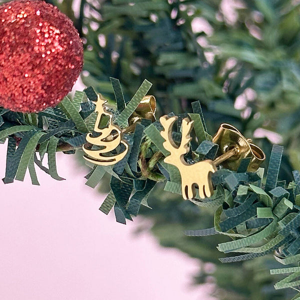 Image shows gold plated christmas tree and reindeer earrings on a mini christmas tree branch